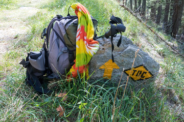 backpack and sticks on the trekking path of the Via Francigena, Aosta Valley, Italy