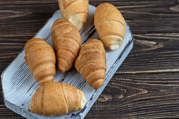 Croissants and coffee for breakfast with fresh raspberry jam on a light background. Decorated with a sprig of mint.