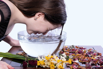 a young girl wants to plunge her face into a cup of water