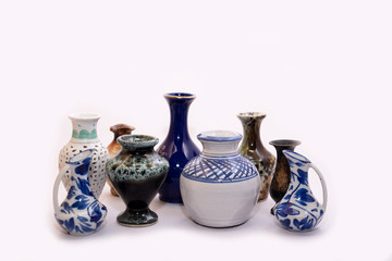 Collection of Small decorated mud pots on white background.