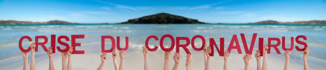 People Hands Holding Colorful French Word Crise Du Coronavirus Means Corona Crisis. Ocean And Beach...