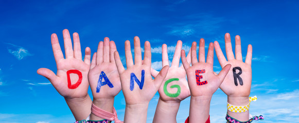 Children Hands Building Colorful English Word Danger. Blue Sky As Background