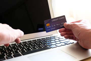 Men hand holding credit card and type payment information on keyboard for order online shopping....