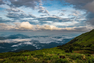 Cloud layers on mountain horizon with green grass