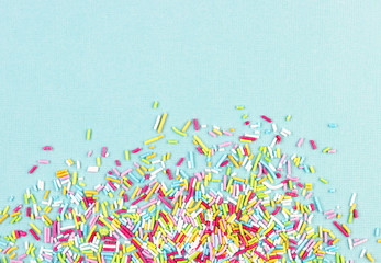 culinary pastry rainbow sprinkles are scattered on a blue background