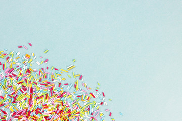 culinary pastry rainbow sprinkles are scattered on a blue background