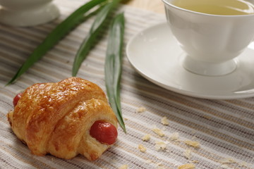 A delicious homemade hotdog croissant with earl grey in the afternoon tea.