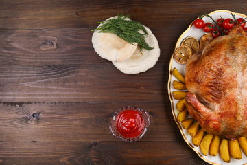 baked chicken on a dish on a wooden surface with copy space. roasted chicken on a plate on dark background