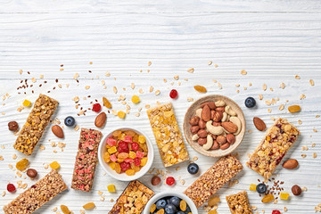 Granola bar with nuts and dry fruit berries. Energy cereal healthy snack. Fitness diet food. Protein muesli bars isolated on white wood. Sport oatmeal bar, top view
