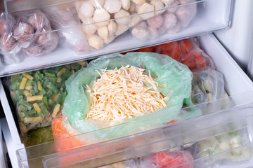 Frozen food in the freezer. Frozen grated cheese