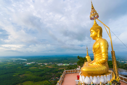 Big golden buddha statue on mountain with cloud