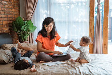 busy businesswoman working while taking care of her children at home