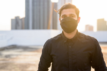 Young Persian businessman wearing mask for protection from corona virus outbreak and pollution