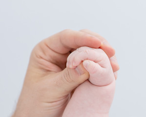 Obraz na płótnie Canvas Close up dad holds tiny hand his newborn baby