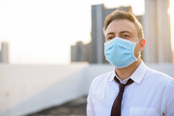 Fototapeta na wymiar Mature businessman wearing mask for protection from corona virus outbreak and pollution