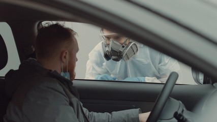 Patient is being tested in his vehicle on a drive-through coronavirus COVID-19 testing location. Pandemic, infection