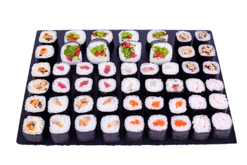Maki Sushi set rolls with fresh ingredients. Rolls on black stone isolated on white background. Sushi menu. Japanese food.