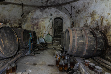 weinfaesser und flaschen in einem keller