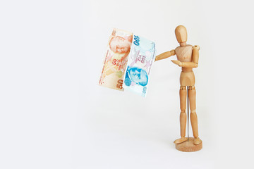 wooden yellow mannequin holding currency money turkish lira