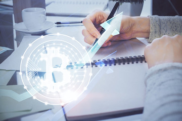 Cryptocurrency hologram over woman's hands writing background. Concept of blockchain. Multi exposure