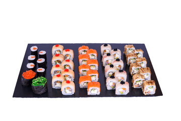 sushi set Tokyo rolls with fresh ingredients on black stone isolated on white background. Sushi menu. Japanese food.