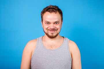 Fototapeta premium Quarantined domestic man standing on a blue background in a t-shirt
