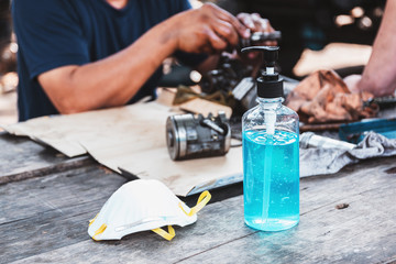 Sanitary mask and alcohol gel for hand washing and cleaning on a wooden table is essential to help prevent infection and spread of the virus.
