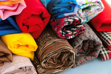 Rolls of fabric close-up. A lot of colorful fabric folded in the form of rolls. Textiles for sewing...