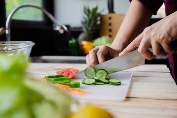 Young man cooking salad on the kitchen, close up.Health care concept