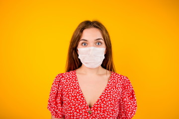 Portrait of a beautiful Slavic girl in a protective medical mask on a yellow background close up