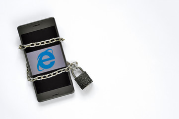 Mobile smart phone in a metal chain on the padlock on white background.
