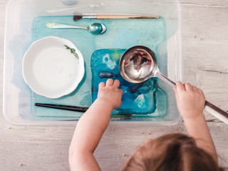 With the help of water, a child melts ice in which animal figures are frozen. The development of...