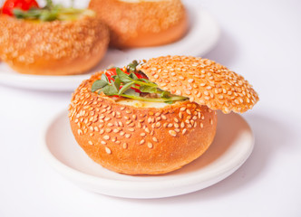 Egg served in bread bowl. Breakfast baked eggs in bread bowls with the fresh herbs.