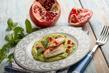 fillet fish over green peas cream with pomegranate