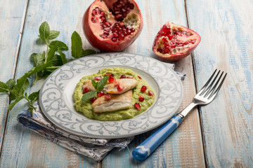 fillet fish over green peas cream with pomegranate