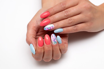 Peach, white, blue shiny manicure on oval long nails with crystals and stains on nameless nails. Summer manicure. Balloons. Abstraction on the nails. Close-up. White background.
