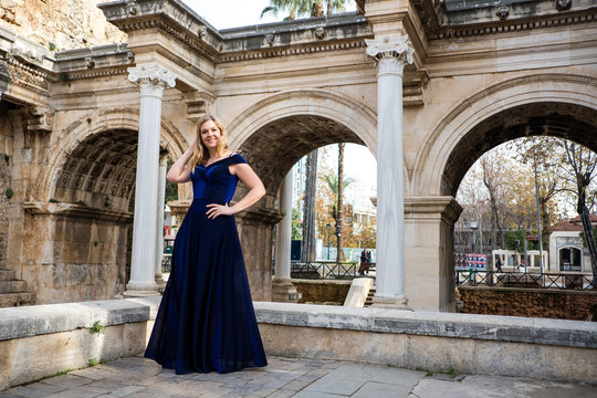Frau in schickem Abendkleid steht vor historischem Geb&auml;ude