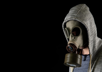 Portrait of a man in an old gas military mask on a black background. Copy space