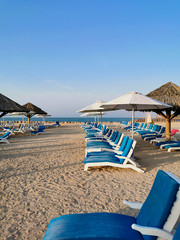 Sonnenliegen und Sonnenschirm am Sandstrand