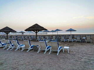 Obraz premium Sonnenliegen und Sonnenschirm am Sandstrand