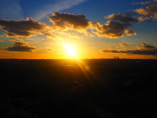 Puesta de sol amarillenta y nubosa en las montañas frente a Madrid