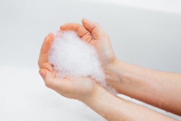 Fototapeta premium Foam in the hands of a girl, washing hands