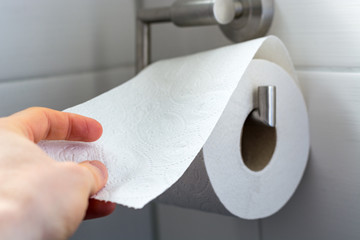 Man grabs toilet paper as a close up