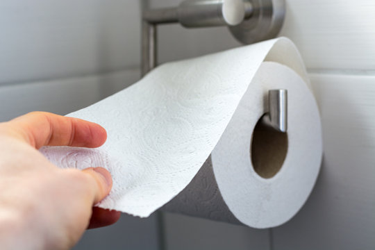 Man grabs toilet paper as a close up