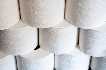 Piled up toilet paper rolls close up from the front at an angle