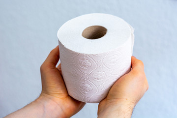 Man holds one toilet paper roll close up