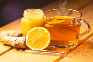 Lemon, citrus, honey and ginger. Natural antiviral products for immunity, health. Wood background. thermometer and tea. antipyretic.