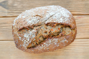 Homemade bread without yeast with carrots. Brown pastries with carrots and nuts. Top view, lies on a wooden board