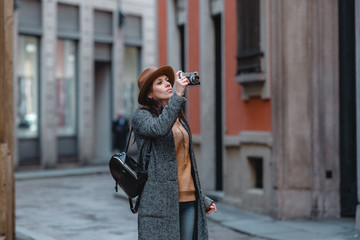 Beautiful girl tourist walks and takes pictures of the building.