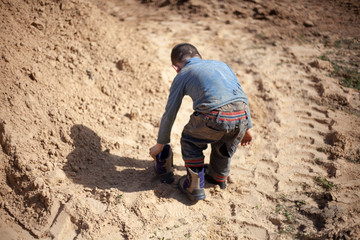 A boy plays in the sandbox.